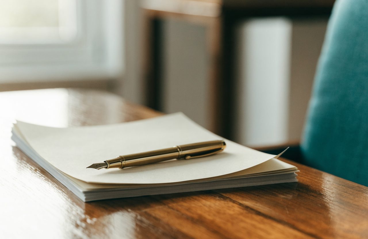 Gold fountain pen resting on documents ready for notarization